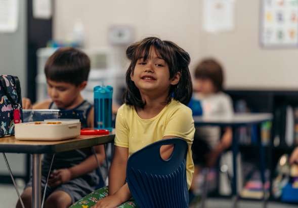 child smiling in a classroom